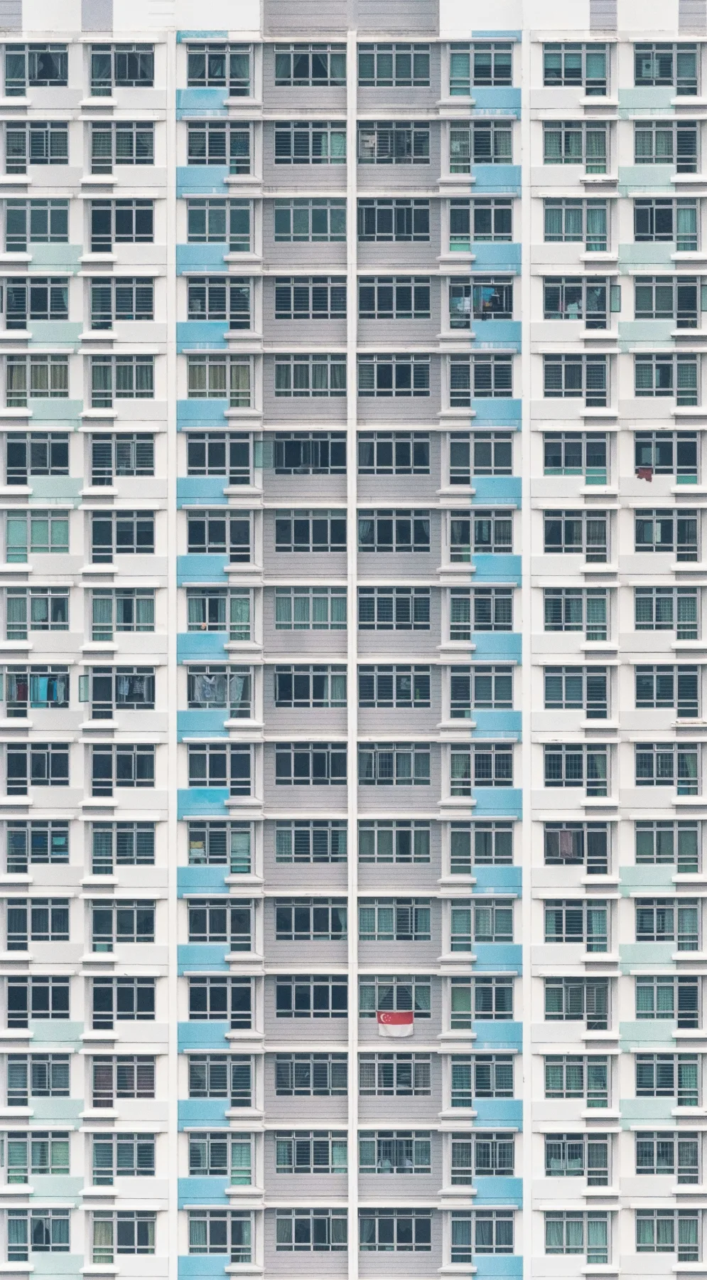 Full facade of a high-rise residential tower showing dozens of identical unit balconies and windows