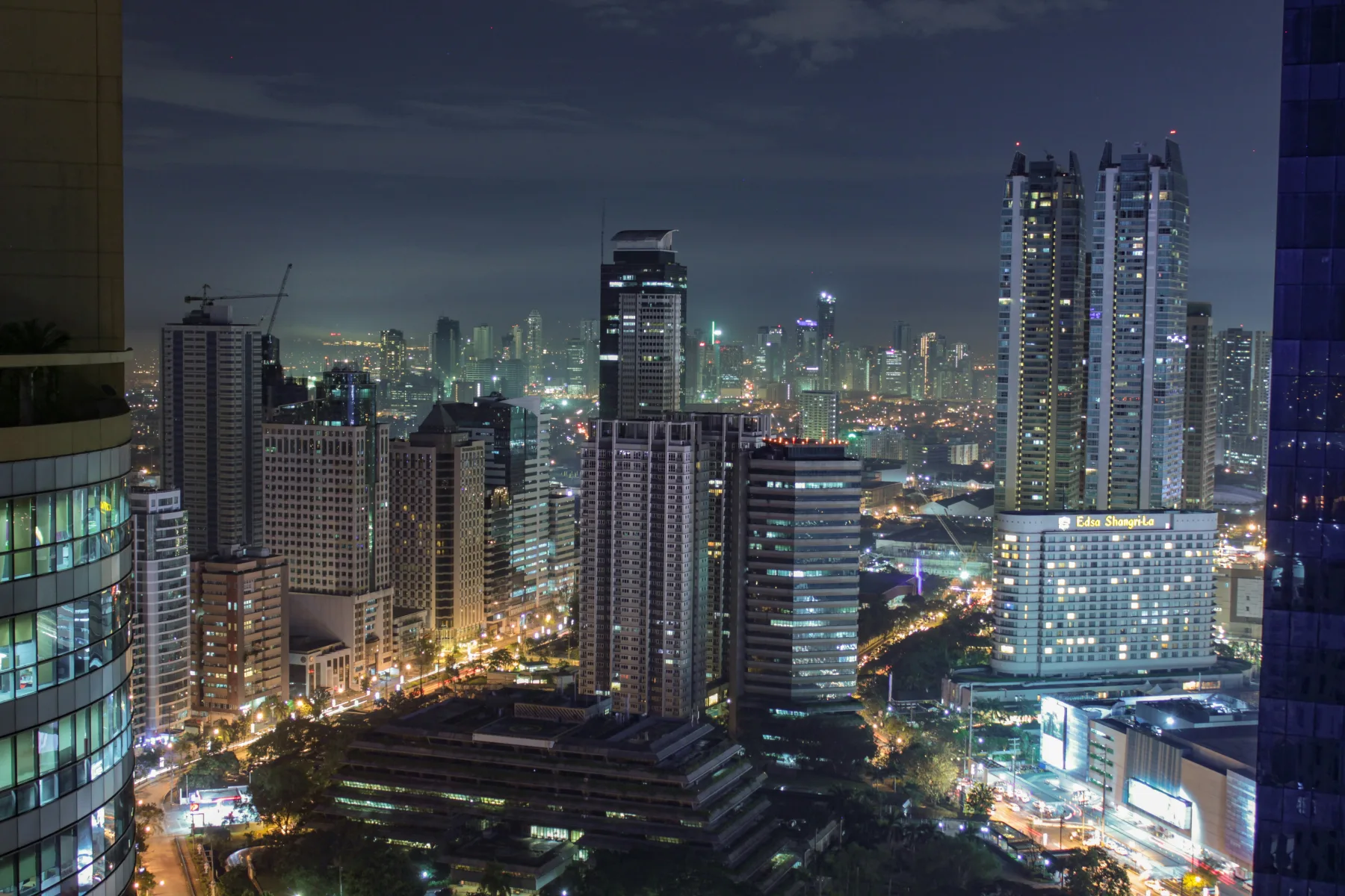 Aerial night view of the Ortigas Center skyline in Metro Manila, with the Edsa Shangri-La hotel and a cluster of lit-up high-rise condominium towers