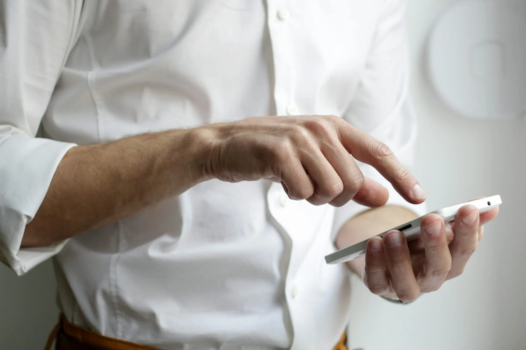 Close-up of a hand tapping a smartphone screen with a fingertip