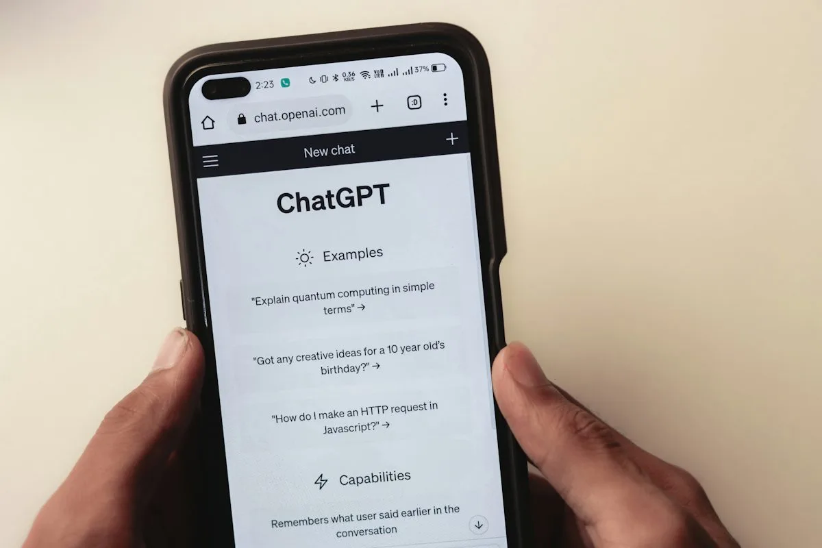 A phone held in two hands with a web browser open, address bar visible at the top, showing a website's homepage