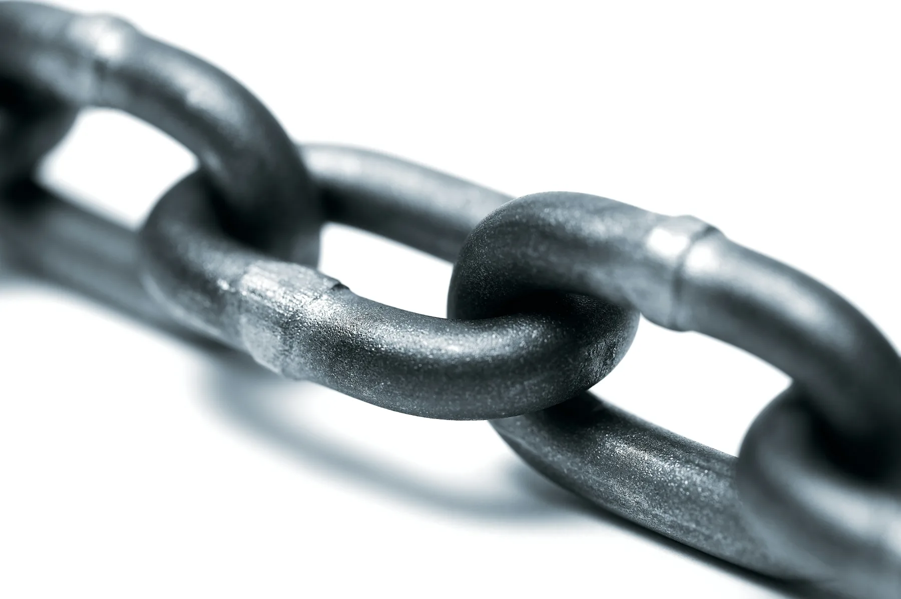 A close-up macro shot of interlocking dark metal chain links