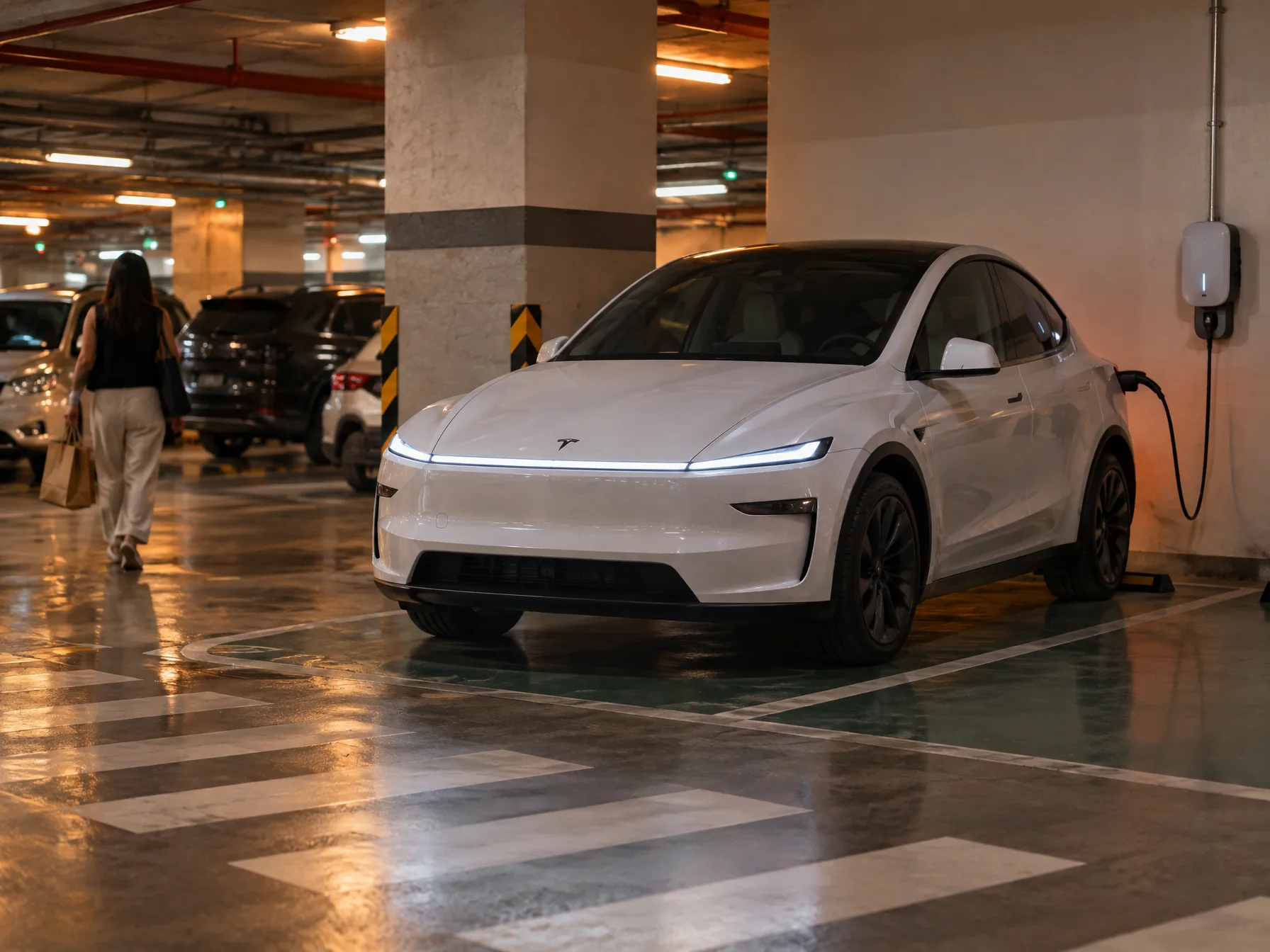Row of EV chargers in a Philippine mall parking lot with several electric cars plugged in