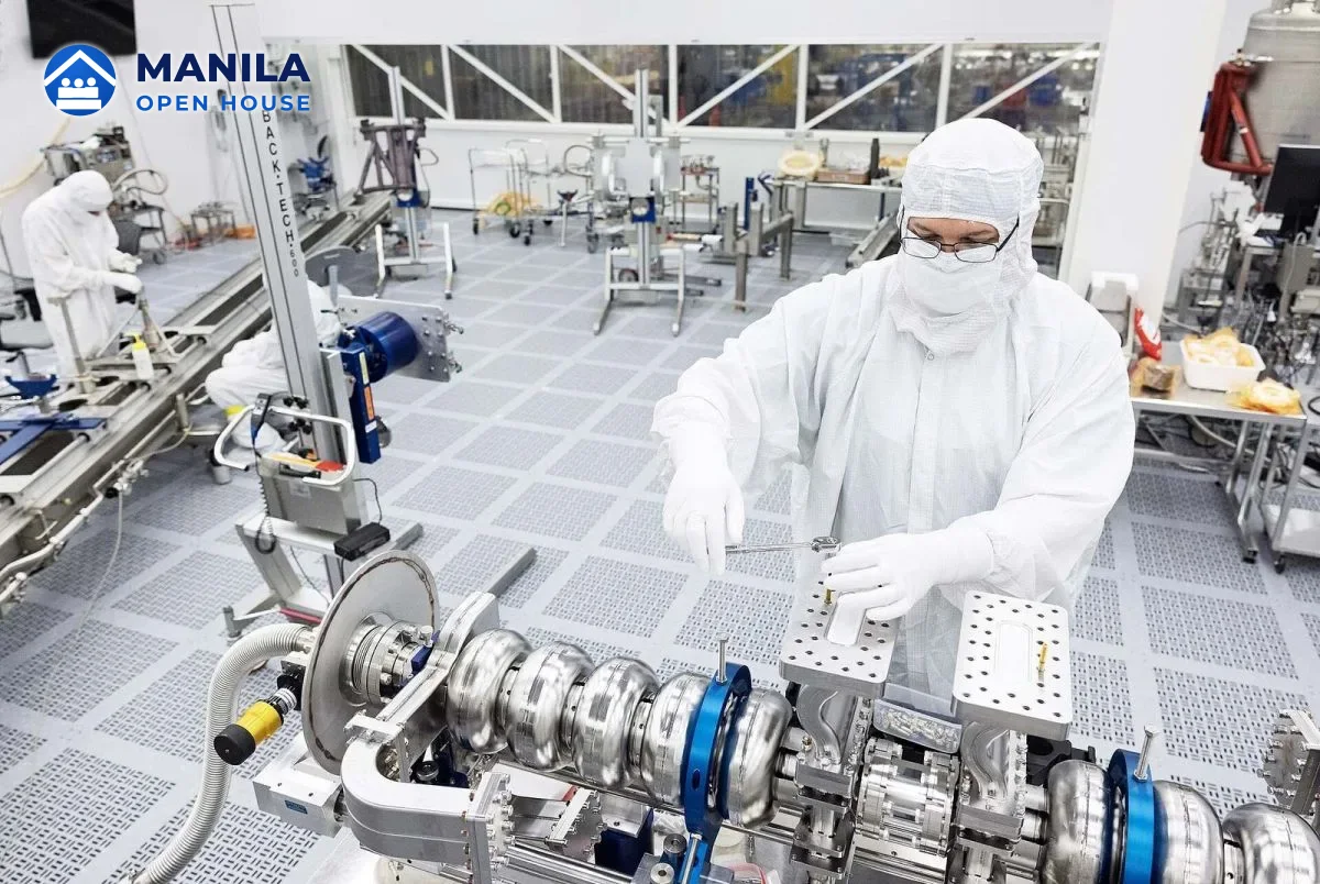 Technicians in cleanroom suits assembling precision equipment in a semiconductor-grade clean room