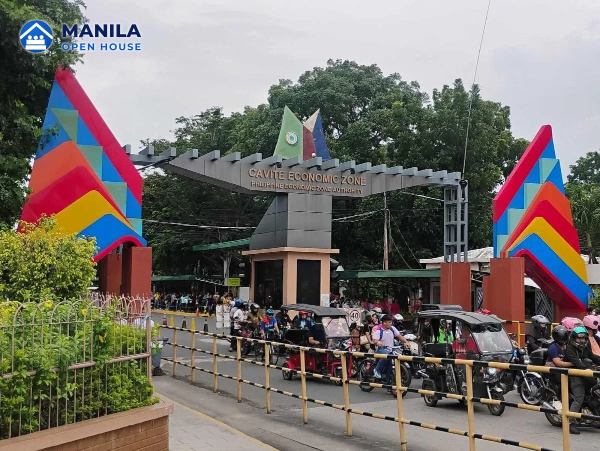 Colorful main gate of the PEZA-run Cavite Economic Zone in Rosario, Cavite, with workers arriving by tricycle